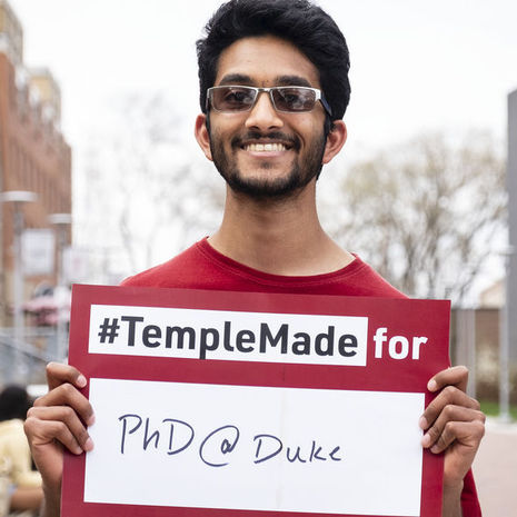 Srikar Katta holding a sign reading Temple Made for PhD@Duke