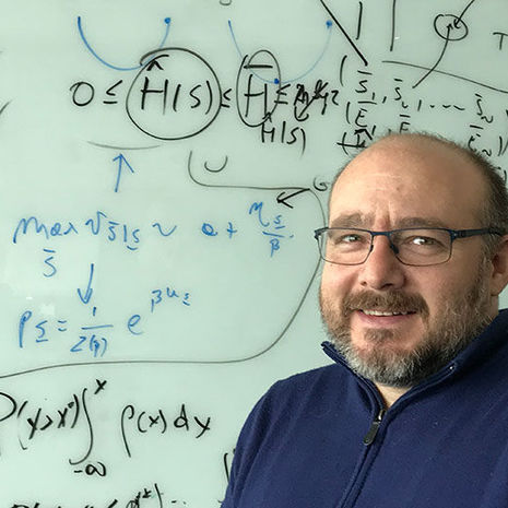 Associate Professor of Biology Vincenzo Carnevale in front of white board with equations