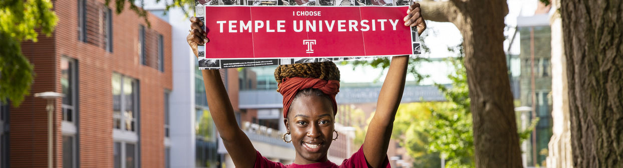 Student holding "I choose Temple University" sign