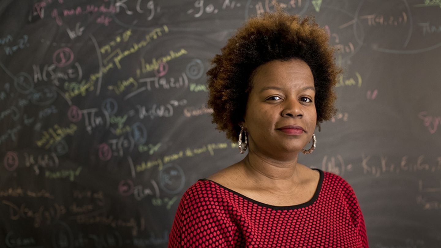 Chelsea Walton, a 2017 Sloan Foundation Research Fellow, specializes in noncommutative algebra.
Chelsea Walton standing in front of a blackboard full of math equations