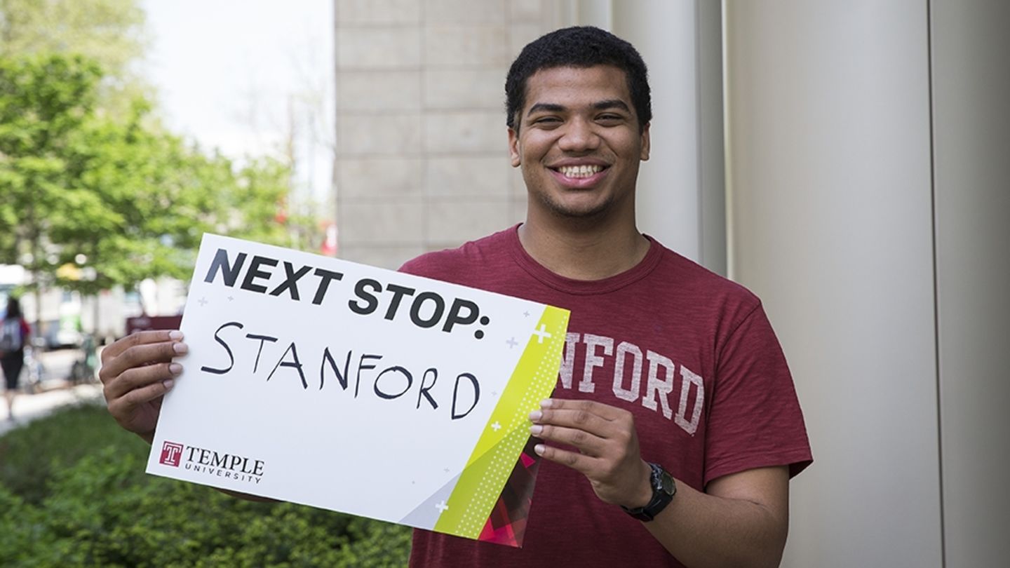 Senior Chey Jones, a chemistry major, cites hands-on lab work as a formative experience of his undergraduate years. Next, he'll head to Stanford. Chey Jones holding a sign for his next stop, Stanford University.