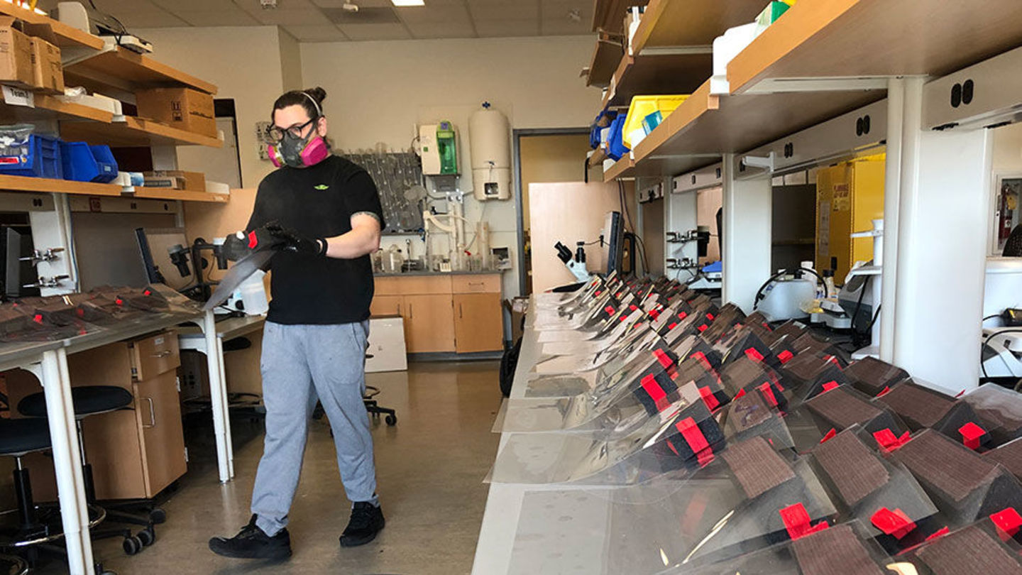 Bioengineering graduate student Kyle Schwab organizes a delivery of face shields. student organizing face shields for delivery