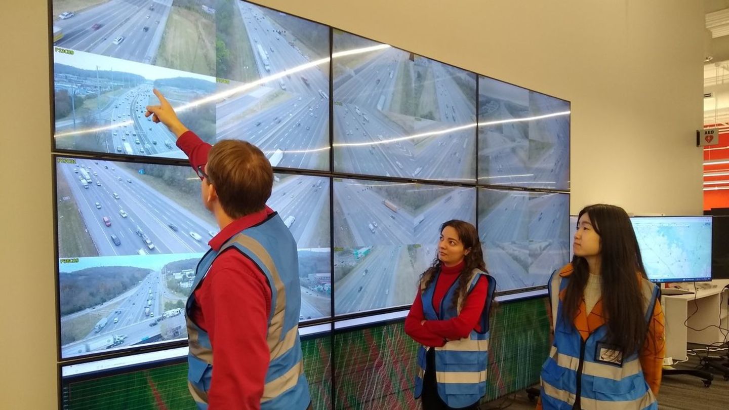 The study demonstrated that vehicles with automation capabilities can make traffic flow more smoothly, reduce greenhouse gas emissions, and keep drivers safe. Researchers review data on a screen.